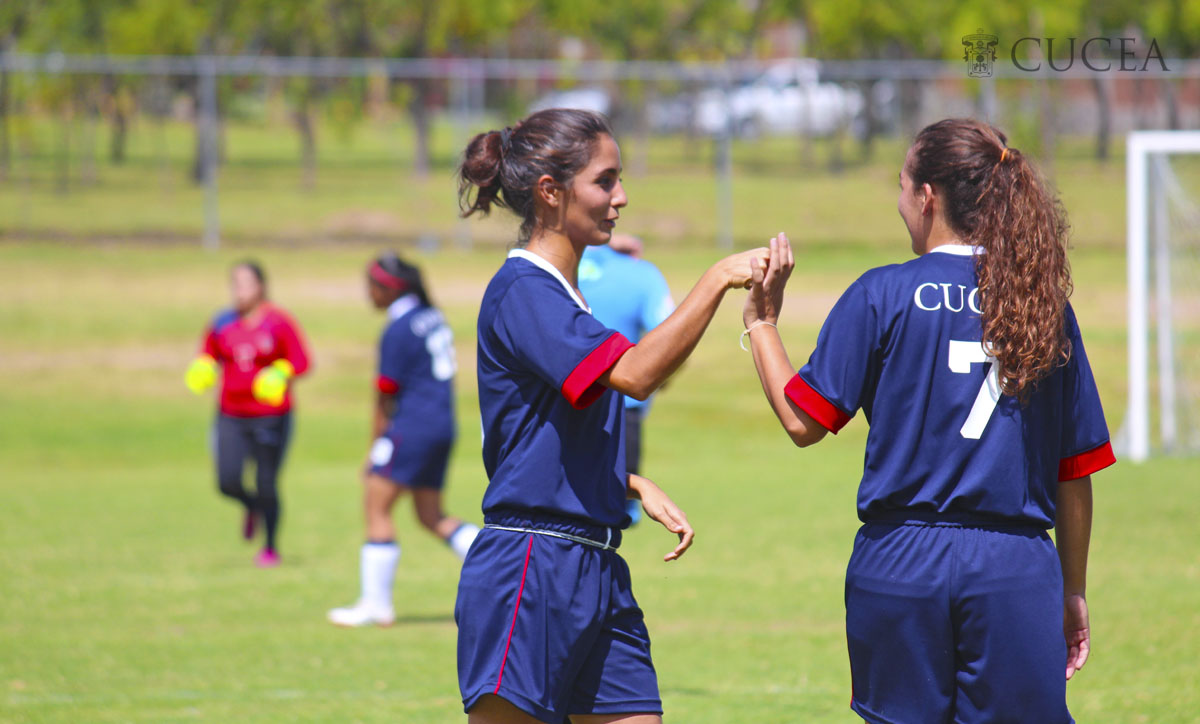 Dos estudiantes jugando futbol haciendo un saludo